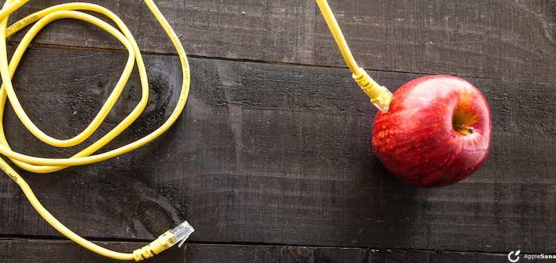 Concept of internet of things , one plugged into a network cable apple on wooden background